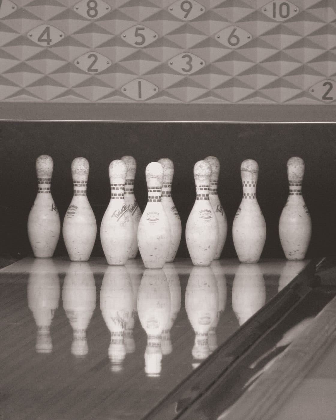Dieci birilli in fila in fondo a una pista da bowling